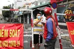 FILE PHOTO: A man living in an area under lockdown receives food through a barricade during the coronavirus disease (COVID-19) pandemic in Ho Chi Minh City, Vietnam July 20, 2021. REUTERS/Stringer