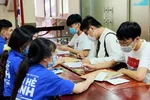 Thí sinh trúng tuyển vào Trường Đại học Khoa học Tự nhiên - Đại học Quốc gia TPHCM đang được hướng dẫn điền thông tin xin nhập học Ảnh: HOÀNG HÙNG