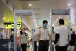 Nhân viên an ninh hàng không kiểm soát hành khách tại khu vực soi chiếu. (Ảnh: Huy Hùng/TTXVN)