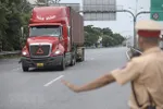 Lực lượng chức năng kiểm tra xe vận chuyển hàng hóa tại một chốt kiểm soát dịch COVID-19. (Ảnh: TTXVN)