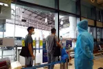 Hành khách tới sân bay Nội Bài phải đo kiểm tra thân nhiệt. (Ảnh: Huy Hùng/TTXVN)