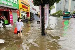 Người dân Hà Nội vất vả di chuyển trong cơn ngập lịch sử chiều 29-5 - Ảnh: QUANG THẾ