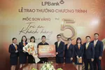 Đại diện LPBank trao tặng sổ tiết kiệm trị giá 50 triệu đồng cho anh Bùi Đức Doanh – khách hàng cá nhân thứ 5 triệu