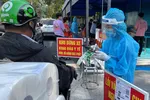 Nhân viên y tế hỗ trợ người dân khai báo y tế khi đến khám chữa bệnh tại Bệnh viện 175. Ảnh: HOÀNG HÙNG