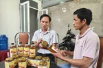 Ông Nguyễn Hồng Châu (bên phải) thuyết minh về sản phẩm mật ong do người dân sản xuất