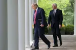 U.S. President Donald Trump walks down the West Wing colonnade from the Oval Office with Vice President Mike Pence as they arrive to address the daily coronavirus task force briefing in the Rose Garden at the White House on April 14. © Reuters