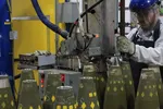Một công nhân đang sản xuất đạn pháo 155mm tại Nhà máy Đạn dược Quân đội McAlester ở McAlester, Okla.