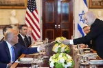 Thủ tướng Israel Benjamin Netanyahu, bên phải, trao cho Tổng thống Donald Trump một tập tài liệu trong cuộc họp tại Phòng Xanh của Nhà Trắng, thứ Hai, ngày 7-7-2025, tại Washington. 