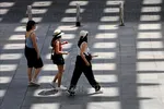 Người dân di chuyển trên đường phố dưới trời nắng nóng tại Seville, Tây Ban Nha. Ảnh: THX/TTXVN