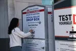 Cử tri bỏ phiếu qua hòm thư của USPS tại điểm bầu cử Thư viện Cleveland Park, Washington D.C. Ảnh tư liệu: TTXVN 