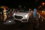 Cảnh sát giao thông yêu cầu dừng xe để kiểm tra thân nhiệt. Ảnh: DŨNG PHƯƠNG