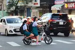 Học sinh chạy xe điện nhưng không đội nón bảo hiểm. Ảnh: ĐOÀN HIỆP