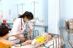 Bác sĩ Bệnh viện Nhi đồng 1 đang thăm khám và điều trị cho bệnh nhi mắc tay chân miệng Ảnh: MINH NAM