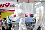Nhân viên y tế chuyển bệnh nhân nhiễm Covid-19 tới bệnh viện ở Daegu, Hàn Quốc ngày 4-3