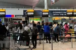 Công dân Việt Nam tại Anh xếp hàng chờ làm thủ tục lên máy bay về nước. (Ảnh: Đình Thư/TTXVN)