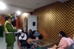 Lực lượng chức năng lập biên bản, xử phạt và đưa đi cách ly nhóm người vi phạm. (Ảnh: TTXVN phát)