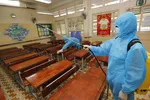 Nhân viên Trường tiểu học Lương Định Của, quận 3, TP.HCM vệ sinh khử khuẩn phòng học chuẩn bị đón học sinh lớp 1 đi học trở lại - Ảnh: NHƯ HÙNG