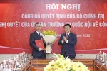Chủ tịch Quốc hội Vương Đình Huệ trao Quyết định của Bộ Chính trị và tặng hoa ông Ngô Văn Tuấn. (Ảnh: Doãn Tấn/TTXVN)