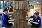 Công nhân Công ty Cổ phần Chế biến gỗ Thuận An kiểm tra các sản phẩm gỗ xuất khẩu. (Ảnh: TTXVN)