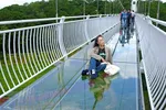 Một khách du lịch tạo dáng chụp hình sống ảo trên cầu kính duy nhất ở Tây Nguyên. (Ảnh: Nguyễn Dũng/TTXVN)
