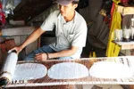 Anh Nguyễn Văn Tài ở ấp Hậu Thuận, xã Hậu Thành, huyện Cái Bè, tỉnh Tiền Giang đặt bánh vừa tráng vào vỉ để phơi khô. (Ảnh: Hữu Chí/TTXVN)