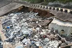 Đoạn kè ven biển dài khoảng 60m bị sóng biển khoét sâu vào trong, lộ ra xi măng, cốt thép, đất... (Ảnh: Thanh Thủy/TTXVN) 