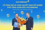 Ông Nguyễn Xuân Ái Quốc nhận quyết định bổ nhiệm và hoa chúc mừng từ ông Loic Faussier - Tổng giám đốc Sacombank