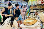 Du khách nước ngoài chọn mua đồ lưu niệm tại chợ Bến Thành (TPHCM). Ảnh: THI HỒNG