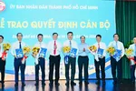 Phó Chủ tịch UBND TPHCM Nguyễn Công Vinh cùng Chánh Văn phòng UBND TPHCM Dương Hồng Thắng trao quyết định và hoa chúc mừng các cá nhân. Ảnh: VIỆT DŨNG