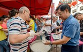 1月13日,在馬來西亞吉隆坡的茨廠街,當地華人社團分發臘八粥給市民。(圖源:新華社)