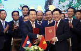 政府副總理、外交部長范平明(前右)與老撾外交部長沙倫塞‧貢瑪西簽署越南外交部與老撾外交部之間行動計劃。(圖源:外交部)