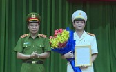 公安部副部長黎貴王向黎鴻南大校(右)頒發人事委任《決定》並送祝賀鮮花。(圖源:H.T)