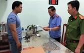黎明山(左)站立著聽取執法警員宣讀逮捕令。(圖源:BPN)