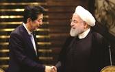 日本首相(左)與伊朗最高領導人握手。