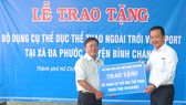 Ông Võ Trọng Nam (phải, Phó Giám đốc Sở VH-TT TPHCM) trao bảng tặng tượng trưng cho ông Phạm Thanh Hùng, Phó chủ tịch UBND xã Đa Phước.