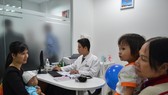 Phụ huynh đưa con đi chích ngừa tại Trung tâm tiêm chủng VNVC