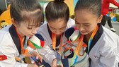 Ba VĐV Taekwondo Việt Nam đã vượt qua chủ nhà Hàn Quốc để giành HCV. Ảnh: NGUYỄN THANH HUY