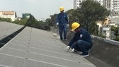 Nhân viên ngành điện lắp đặt điện mặt trời áp mái cho một đơn vị trên địa bàn TPHCM