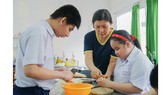 Cô Nguyễn Thị Kim Phượng hướng dẫn học trò những kỹ năng hàng ngày, giúp các em hòa nhập với cuộc sống. Ảnh: HOÀNG HÙNG