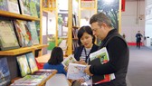 Một đối tác nước ngoài đang tìm hiểu các ấn phẩm của Việt Nam tại Hội sách Frankfurt 2019. Ảnh: HÒA LONG