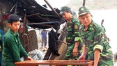 Chiến sĩ bộ đội biên phòng tỉnh Bình Định hỗ trợ người dân khắc phục hậu quả sau bão. Ảnh: XUÂN HUYÊN