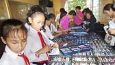 Các học sinh vùng sâu tỉnh Kiên Giang lựa kính do đoàn khám bệnh từ thiện của Hội Mắt kính TPHCM tặng