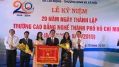 Ông Lê Minh Tấn, Giám đốc Sở LĐTB-XH TPHCM ( ngoài cùng bên trái) đại diện UBND TPHCM trao bức trướng của UBND TPHCM cho Ban Giám hiệu nhà trường