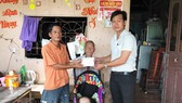 Đại diện Báo SGGP (bìa phải) trao tiền cho anh Lộc từ sự hỗ trợ của mạnh thường quân