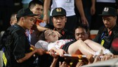 Nữ CĐV được đưa đi bệnh việni. Ảnh: VĂN LÂM