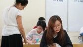 Thí sinh làm thủ tục đăng ký dự thi ở trường THPT Thăng Long, Hà Nội. Ảnh: VIẾT CHUNG