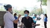 Đo thân nhiệt cho thí sinh. Ảnh: QUANG PHÚC