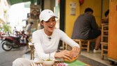 Miss Universe Vietnam 2017 H'Hen Nie has banh mi at the first banh mi shop (Photo: SGGP)
