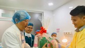 Tiến sĩ- Bác sĩ Lê Quang Thanh - Giám đốc Bệnh viện Từ Dũ tặng quà, chúc mừng gia đình sản phụ. Ảnh: NGỌC DIỆP