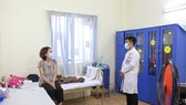 Nhân viên y tế giữ khoảng cách an toàn khi tiếp xúc với người cách ly ảnh: HOÀNG HÙNG